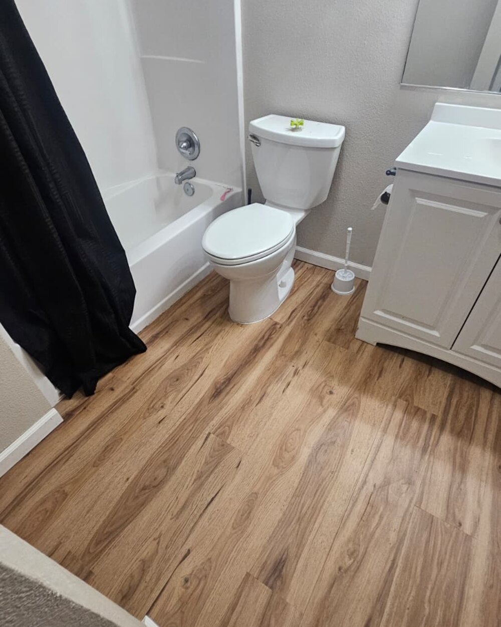 Bathroom with new plank flooring around tub and vanity